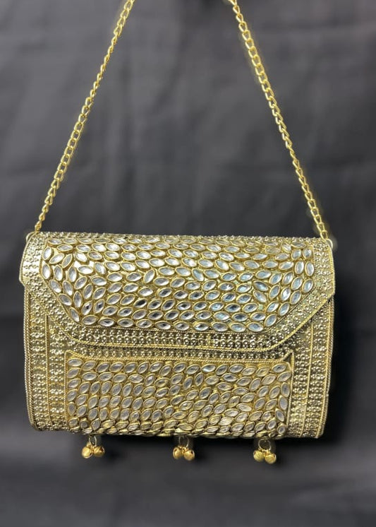 Gold embellished handbag on a dark background